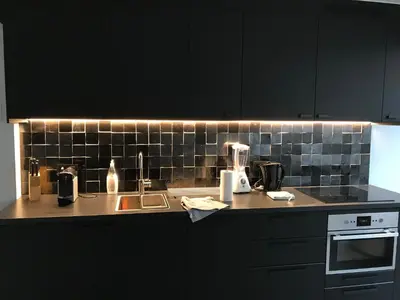 a kitchen with black cabinets and a counter top at LivingTheMoment in Ghent