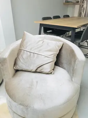 a pillow sitting on a chair in front of a table at LivingTheMoment in Ghent