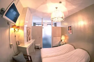 a small bedroom with a bed and a tv in it at Hotel Urban Dreams in Antwerp