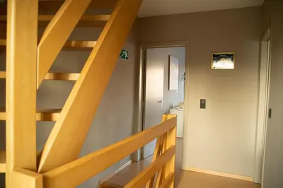 a wooden staircase in a room with a hallway at Room 