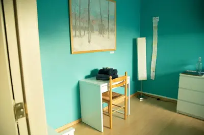 a blue room with a desk and a chair at Room 