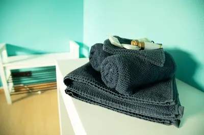 a pile of towels sitting on top of a table at Room 