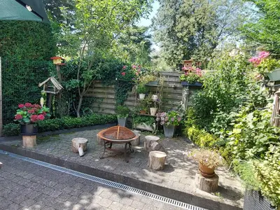 a garden with a table and some trees and flowers at Room 