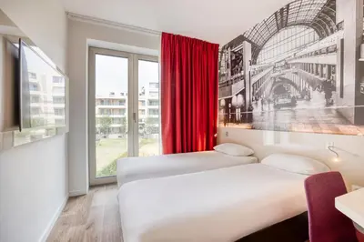 a hotel room with two beds and a window at B&B HOTEL Antwerpen Zuid in Antwerp