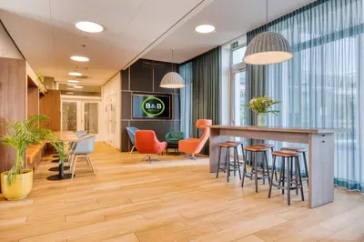 an office lobby with a bar and chairs at B&B HOTEL Antwerpen Zuid in Antwerp