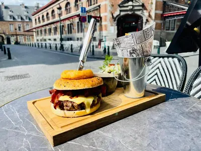 a hamburger on a cutting board on a table at Boutique Hotel Saint-Géry in Brussels