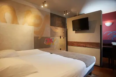 a bedroom with a bed and a flat screen tv at Boutique Hotel Saint-Géry in Brussels