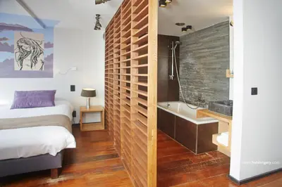 a bedroom with a bed and a bath tub next to a bed sidx sidx sidx at Boutique Hotel Saint-Géry in Brussels