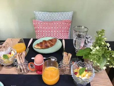 a table topped with a plate of food and orange juice at B&B PETIT PRINCE, GENT in Ghent