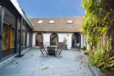 a patio with chairs and a table in front of a house at BNB Nest in Ghent