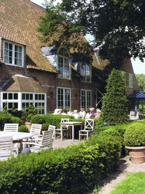 a house with tables and chairs in front of it at Bossenstein Golf & Polo Club in Ranst