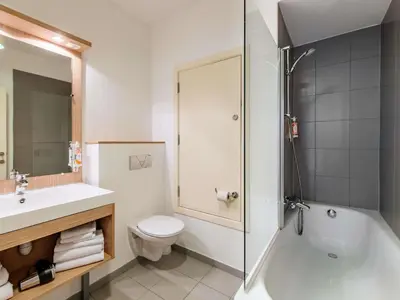 a bathroom with a toilet and a sink and a shower at Aparthotel Adagio Access Bruxelles Europe Aparthotel in Brussels