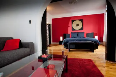 a living room with a bed and a red wall at B&B Luxe Suites 1-2-3 in Antwerp