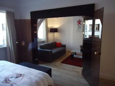 a bedroom with a bed and a couch and a mirror at B&B Luxe Suites 1-2-3 in Antwerp