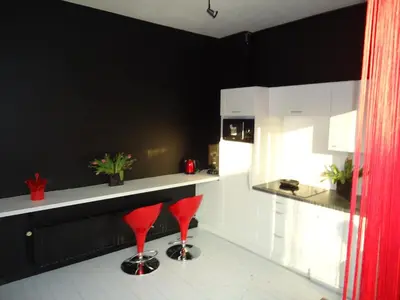 a black and white kitchen with red stools at B&B Luxe Suites 1-2-3 in Antwerp
