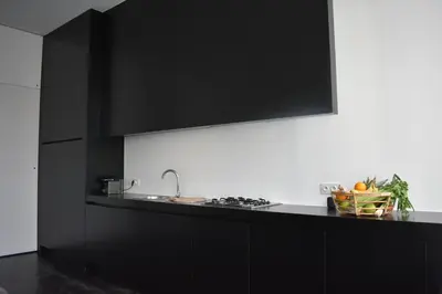 a kitchen with black cabinets and a black counter top at Josie in Ghent