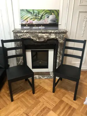 two chairs sitting in front of a fireplace at Rose House B&B in Ghent