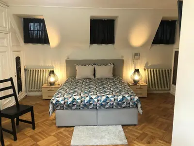 a bedroom with a bed and two lamps on two tables at Rose House B&B in Ghent