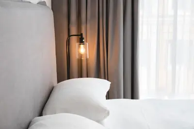 a bedroom with a bed with a light next to a window at Skyline Flats Gent in Ghent