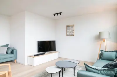 a living room with a couch and a tv at Skyline Flats Gent in Ghent