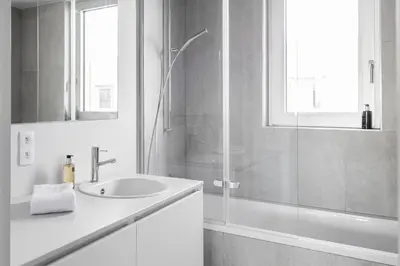 a white bathroom with a sink and a shower at Skyline Flats Gent in Ghent