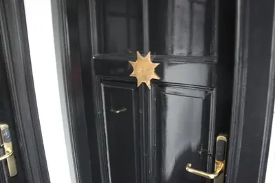 a black door with a gold star on it at Puur B&B in Antwerp