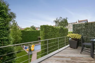 a balcony with a view of a pool in a garden at Puur B&B in Antwerp