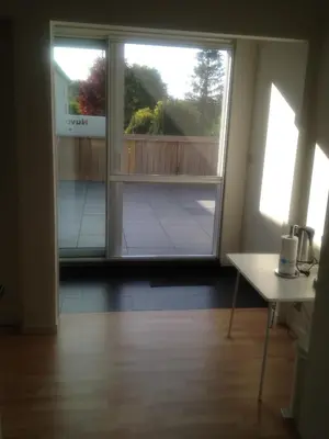 an empty room with a large window and a table at Nuvola Loft in Zottegem