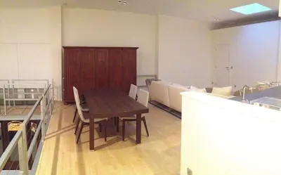 a room with a wooden table and chairs in it at Nuvola Loft in Zottegem