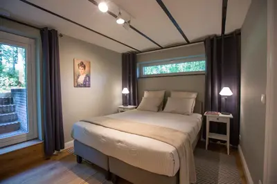 a bedroom with a bed and a large window at Antonine's Atelier in Hingene