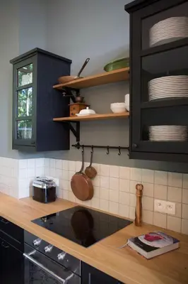 a kitchen with black cabinets and a wooden counter top at Antonine's Atelier in Hingene