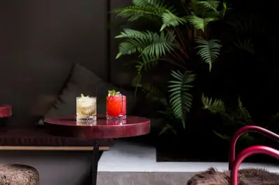 two cocktails sitting on a table in a room at YUST Antwerp in Antwerp