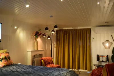 a bedroom with a bed and a green curtain at Biotina in Lebbeke