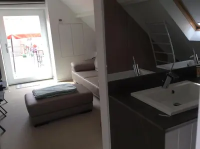 a small bathroom with a sink and a couch at Biotina in Lebbeke