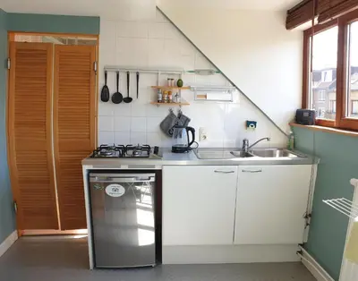 a small kitchen with a stove and a sink at Be.Cosy in Brussels