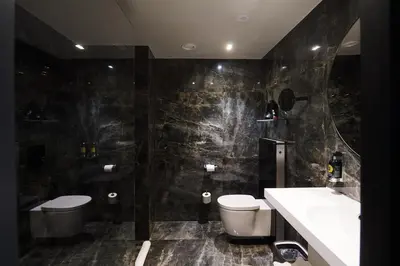 a bathroom with a toilet and a sink and a mirror at Harmon House - Hotel & Spa in Brussels