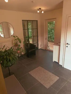 a living room with a chair and a mirror at De Loteling in Zoersel