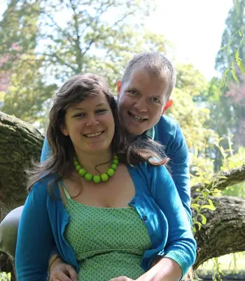 a man and a woman sitting on a tree branch at De Loteling in Zoersel
