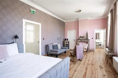 a bedroom with a white bed and a living room at 22b&b in Antwerp