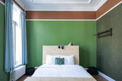 a bedroom with green walls and a white bed at 22b&b in Antwerp