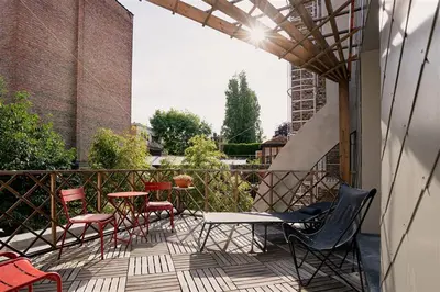 a patio with chairs and tables on a balcony at 22b&b in Antwerp