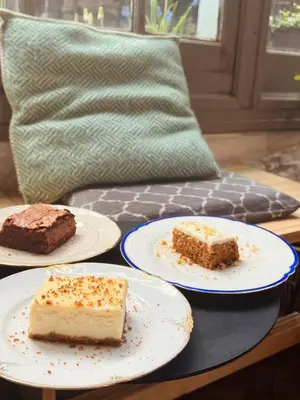 three slices of cake on plates on a table at 22b&b in Antwerp
