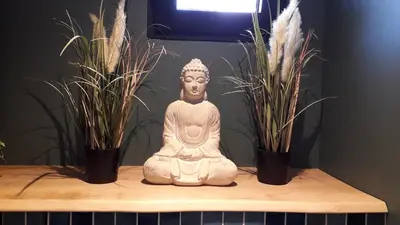 a statue sitting on a table with two potted plants at B&B Alegría in Mechelen