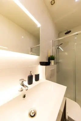 a white bathroom with a sink and a shower at B&B Daya in Kessel-Lo