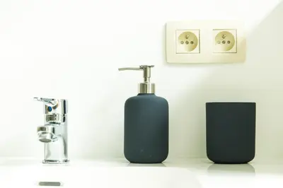two black soap bottles sitting on a bathroom counter at B&B Daya in Kessel-Lo