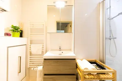 a white bathroom with a sink and a shower at B&B Daya in Kessel-Lo