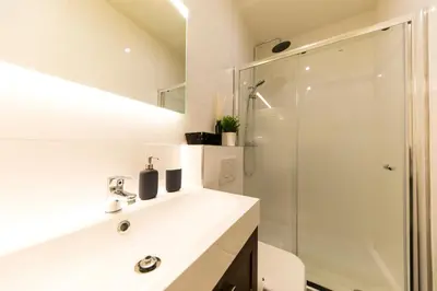 a bathroom with a white sink and a shower at B&B Daya in Kessel-Lo
