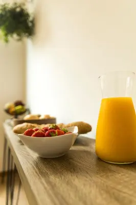 a bowl of fruit and a glass of orange juice on a table at B&B Daya in Kessel-Lo