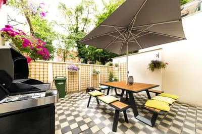 a patio with a table and chairs and an umbrella at B&B Daya in Kessel-Lo