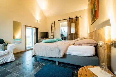 a bedroom with a large bed and a table at B&B Art.14 in Morkhoven